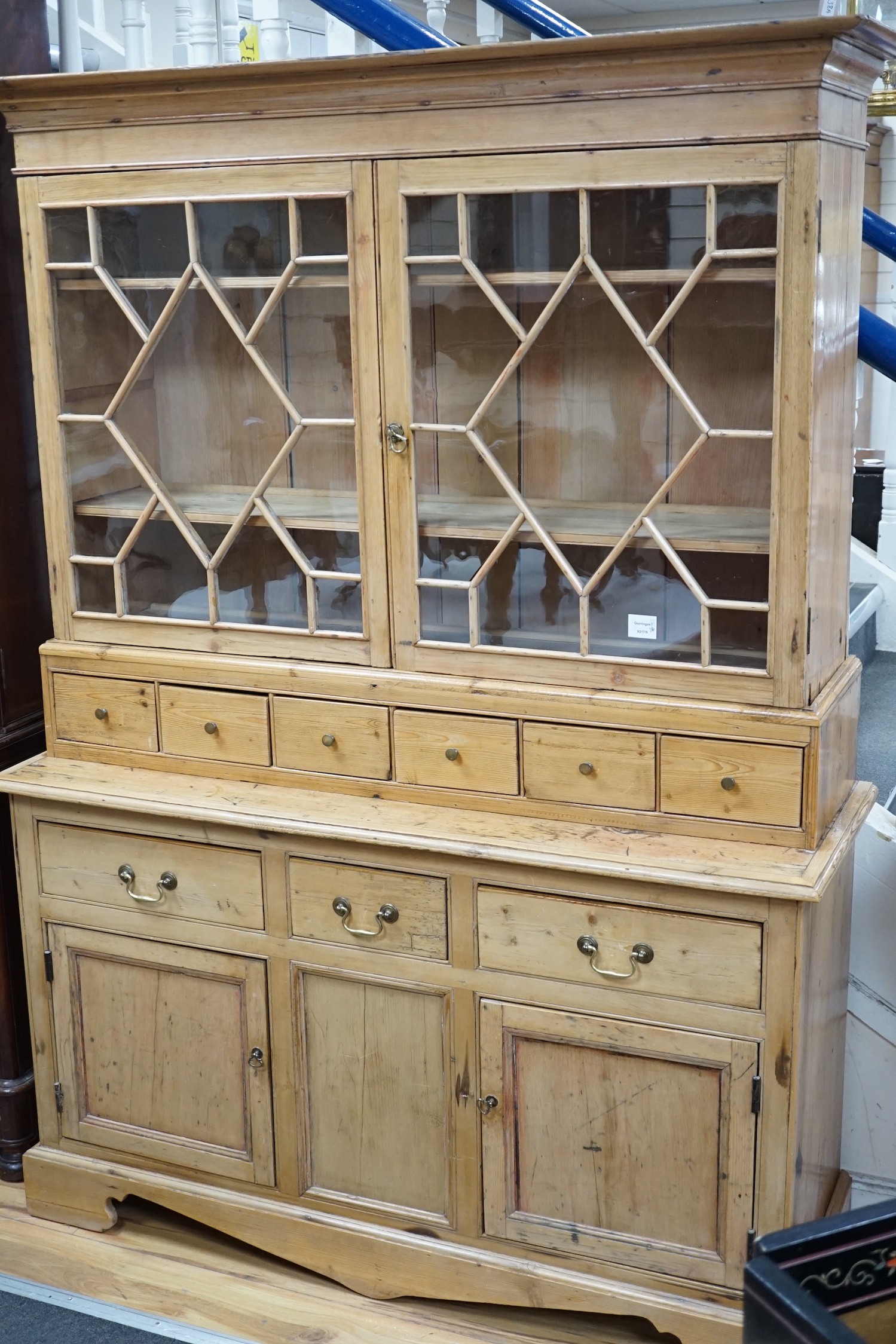 A 19th century pine dresser base of small proportions with an associated glazed cabinet top, width 133cm, height 185cm *Please note the sale commences at 9am.